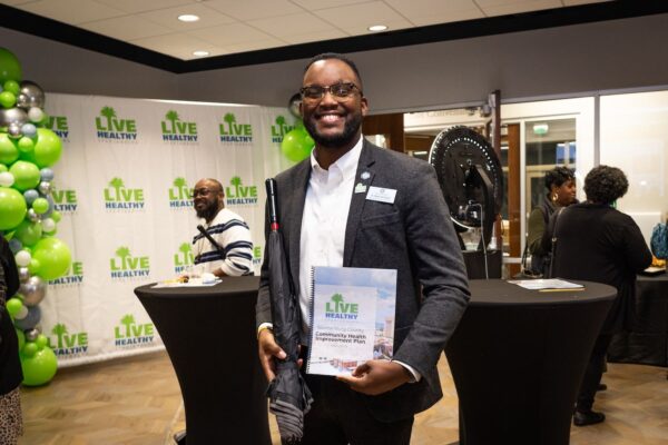 Dr. Midas Hampton, Director of Strategic Spartanburg, holding the 2026-2028 Spartanburg County CHIP